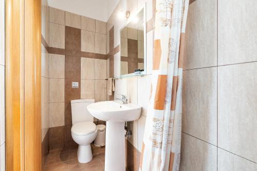 a small bathroom with a toilet and a sink at Green Pearl in Lachania