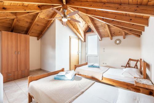 two beds in a room with wooden ceilings at Green Pearl in Lachania