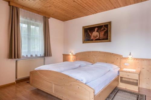 a large bed in a bedroom with a picture on the wall at Haus Thurn Apartment A in Castelrotto