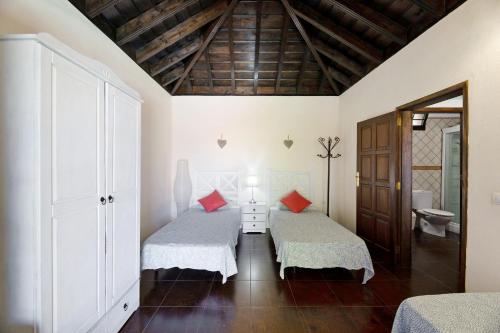 a bedroom with two beds and a wooden ceiling at Casa La Flamenca in Tijarafe