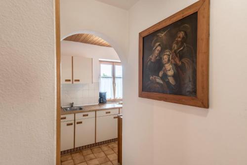 a kitchen with a painting hanging on the wall at Haus Thurn Apartment A in Castelrotto