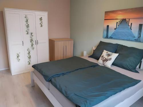 a bedroom with a bed and a painting on the wall at Ferienwohnung Naturglück in Sundhagen-Niederhof