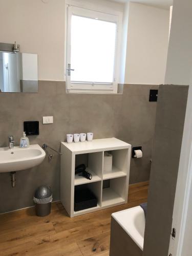 a bathroom with a sink and a toilet and a window at Villa Wetzel Domaso in Montemezzo