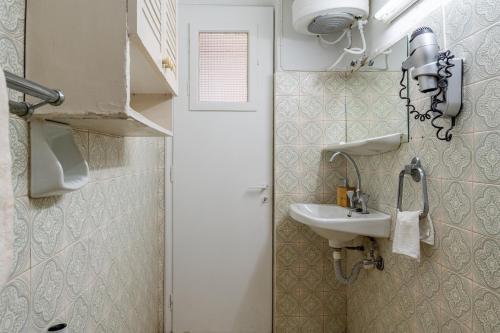 a small bathroom with a sink and a mirror at Villa Marianthi-kaizer Bridge in Achílleion