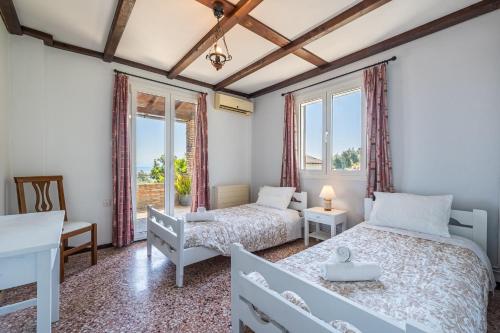 a twin bedroom with two beds and a window at Villa Marianthi-kaizer Bridge in Achílleion