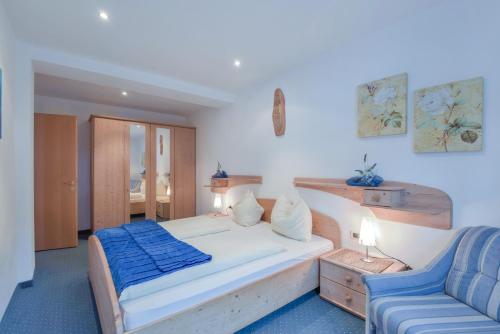 a bedroom with a bed and a blue couch at Apartments Christa App B2 in Ortisei