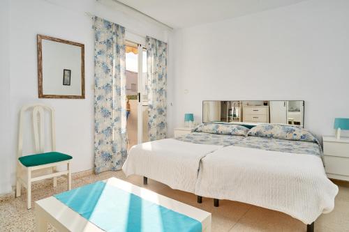 a white bedroom with a bed and a table at Butterfly apartment in Nerja