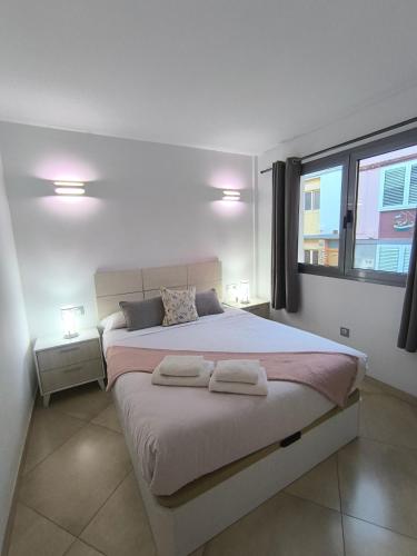 a bedroom with a large bed with two towels on it at Sunset Star Arguineguin in Arguineguín