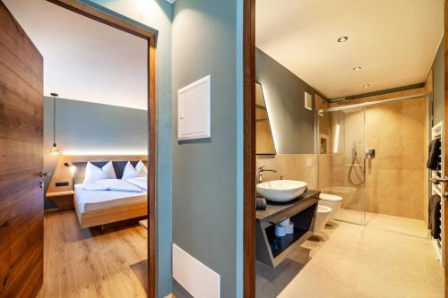 a bathroom with a bed and a sink and a mirror at Aktiv Lodge Meran - Terrace One in San Martino
