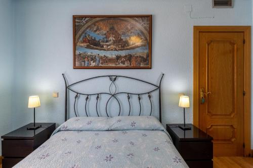 a bedroom with a bed and a painting on the wall at Casa Rural Kalfonso in Mascaraque