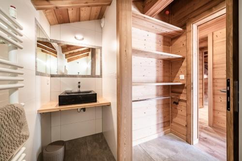 a bathroom with a sink and wooden walls at Chalet Heidi - Chatel in Châtel