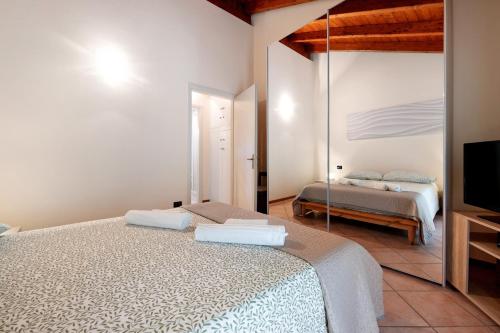 a bedroom with two beds and a flat screen tv at Miralago Marone Holiday House in Marone