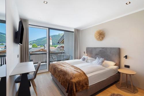 a bedroom with a large bed and a balcony at Appartment Hofer Room Bergnest in Villabassa