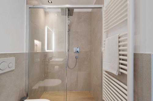 a bathroom with a shower with a glass door at Appartment Hofer Room Bergnest in Villabassa