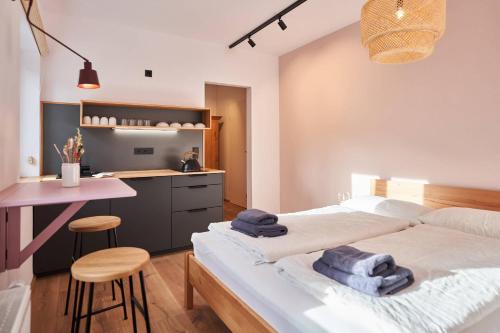 a bedroom with a bed and a table and a kitchen at Alte Seifensiederei - Malala in Bad Tölz