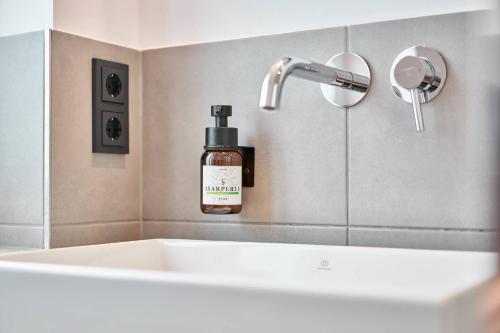 a bottle of soap sitting next to a sink at Alte Seifensiederei - Malala in Bad Tölz