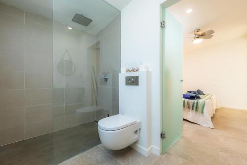 a bathroom with a white toilet and a shower at Es Collet in Manacor