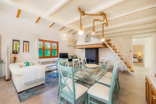 a dining room and living room with a glass table and chairs at Es Collet in Manacor