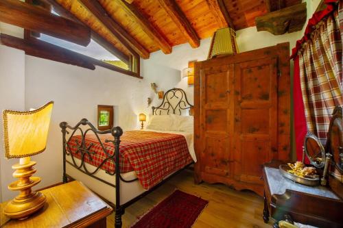 a bedroom with a bed and a wooden ceiling at Le Chalet du Coq Rouge in Valtournenche