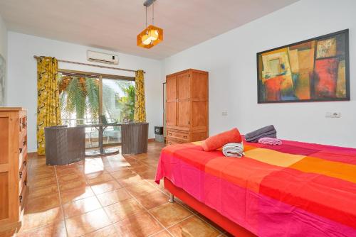 a bedroom with a bed with a colorful blanket at El Nido in Almuñécar