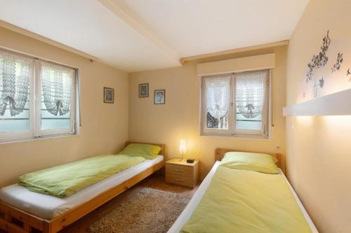 two beds in a room with two windows at Haus am See in Gedern