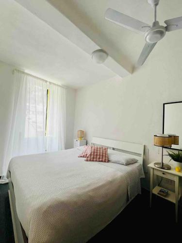 a white bedroom with a bed with a white ceiling at La Terrazza di Vernazza in Vernazza