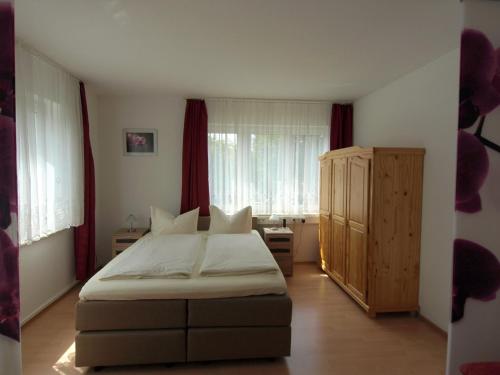 a bedroom with a bed and a window with red curtains at Apartment Mengelberg in Markkleeberg
