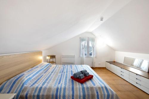a bedroom with a large bed with a red pillow on it at Elena e Joerg 2 in Vezzi Portio