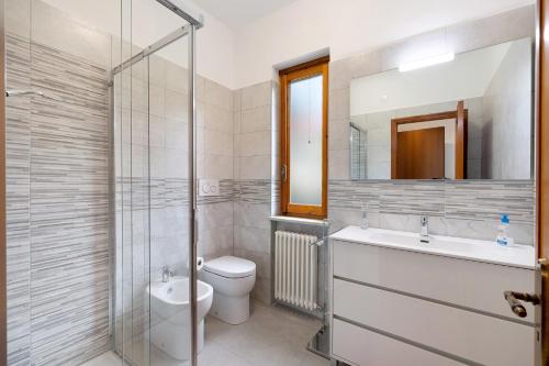 a bathroom with a sink toilet and a mirror at Elena e Joerg 2 in Vezzi Portio