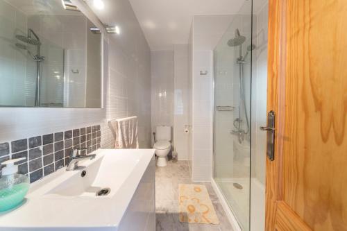a white bathroom with a sink and a shower at 53 Luz Bahia in Mazarrón