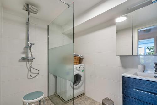 a bathroom with a washing machine and a sink at Appartment Piano in Deisenhofen