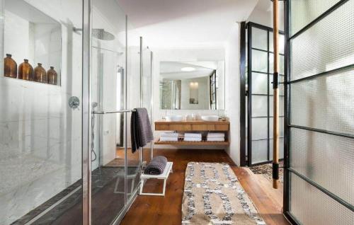 a bathroom with a glass shower and a sink at וילה levi in Chorazim