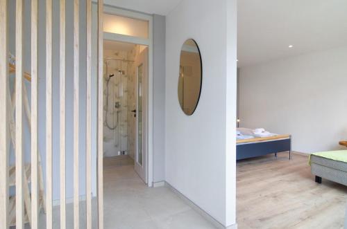 a bathroom with a mirror and a room with a sink at Meili's Haus in Uhldingen-Mühlhofen