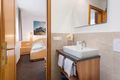 a bathroom with a sink and a bed in a room at Haus Lena in Solda