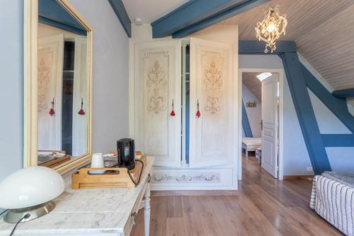a living room with a table and a mirror at Maison d'hôtes, Calme et Piscine in Habas