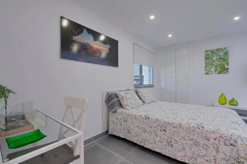 a white bedroom with a bed and a glass table at Loft Cerca Del Mar Tenerife in Punta del Hidalgo
