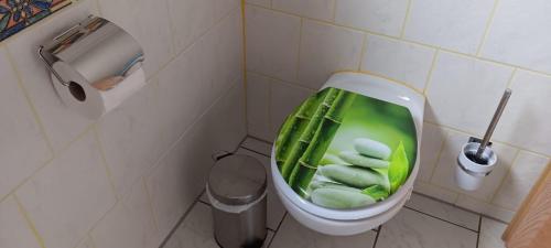 a bathroom with a toilet with green towels in it at Zur Schmiede in Hasselförde
