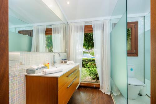 a bathroom with a sink and a toilet and a mirror at Can Toni in Pollença