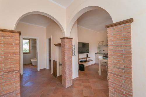 a hallway with arches and a brick pillar at Al posto giusto - appartamento Sole in Riotorto