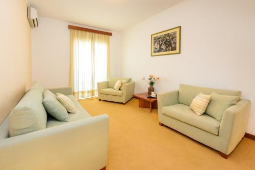 a living room with two couches and two chairs at Akrata Beach Hotel in Akrata