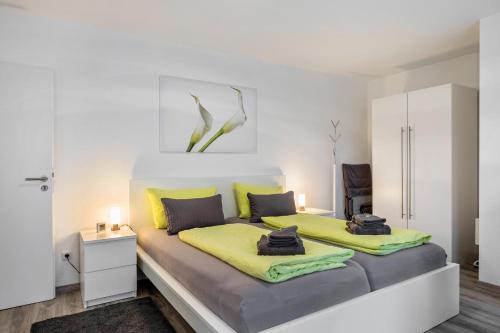 a bedroom with two beds with yellow sheets at Schwarzwaldblick K App 4 mit Pool in Schönwald