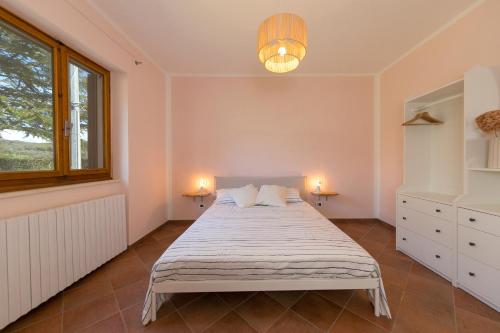 a bedroom with a bed with two lamps and a window at Al posto giusto - appartamento Sole in Riotorto