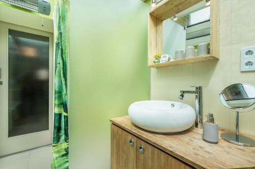a bathroom with a white bowl sink on a wooden counter at Chalet Kunterbunt in Langenwetzendorf