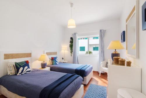 a bedroom with two beds and a living room at Prainha Paradise - Algarve in Alvor