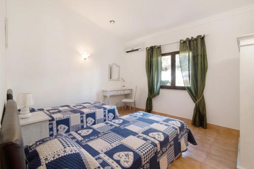 a bedroom with two beds and a window at Vila Filipa in Guia