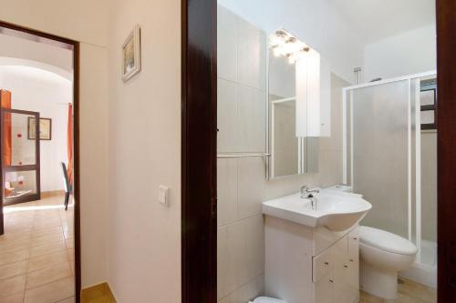 a white bathroom with a sink and a toilet at Vila Filipa in Guia