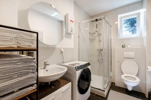 a bathroom with a sink and a toilet and a shower at Ferienwohnung in München Eg in Munich