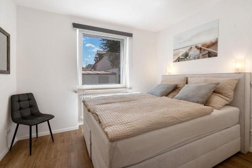 a white bedroom with a bed and a window at Ferienwohnung in München Eg in Munich