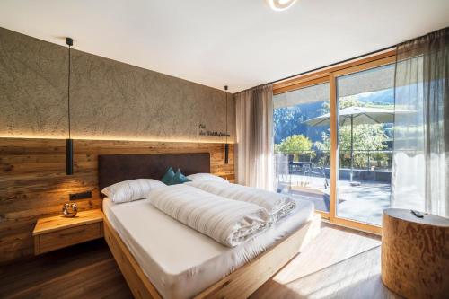 a bedroom with a large bed and a large window at Chalet Riad in Saltusio