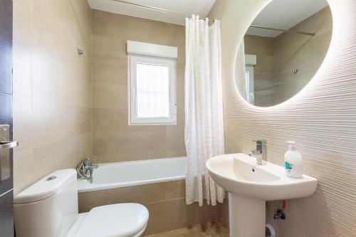 a bathroom with a sink and a toilet and a mirror at Nido in Níjar
